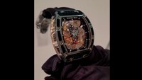 Muka piringan atau dial jam ini berbentuk patung naga yang sangat detail. Warna naga ini adalah emas dengan aksen merah di lidah. Jarum penunjuk waktu juga berwarna emas. Kepala gigi atau crown berbentuk bak kubah dengan ujung melancip, warnanya hitam. (Dok Tony Sutrisno)