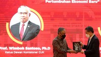 Ketua Dewan Komisioner Otoritas Jasa Keuangan (OJK) Wimboh Santoso (kiri) menerima cinderamata kepada Rektor Universitas Syiah Kuala (USK) Marwan (kanan) usai menyampaikan materi pada kuliah umum di aula Gedung AAC Dayan Dawood, Banda Aceh, Aceh.