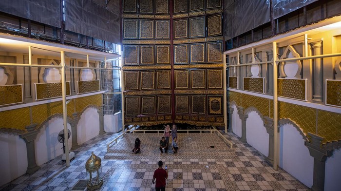 Megahnya Al-Qur'an Raksasa di Palembang Berukir Tinta Emas Pengunjung membaca ayat-ayat suci yang ada di Al Quran Al-Akbar di Palembang, Sumatera Selatan, Sabtu (9/4/2022). Keberadaan Al Quran raksasa yang diukir di atas kayu trembesi itu menjadi destinasi wisata religi di Kota Palembang selama bulan suci Ramadhan. ANTARA FOTO/Nova Wahyudi/wsj.