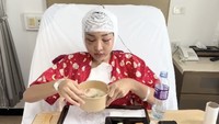 Saat sedang jalani pemulihan pascaoperasi di rumah sakit, Lucinta Luna disuguhi bubur. Terlihat area mata, hidung, hingga bibirnya masih bengkak. 