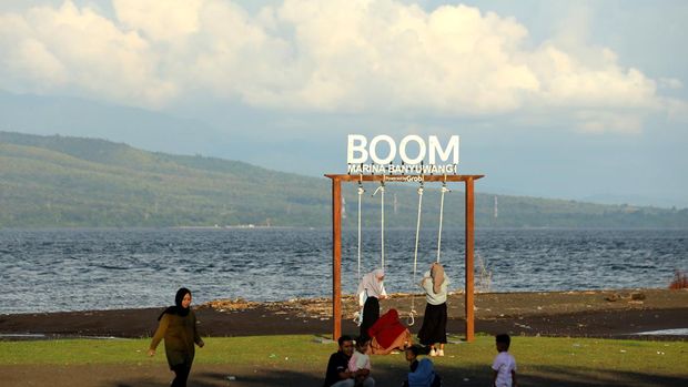 Pengunjung menikmati suasana di Jembatan Pulau Wangi usai berbuka puasa di Pantai Marina Boom, Banyuwangi, Jawa Timur, Selasa (5/4/2022). Sebagian umat muslim di Banyuwangi memilih untuk menunggu waktu berbuka puasa sambil berwisata. ANTARA FOTO/Budi Candra Setya/hp.