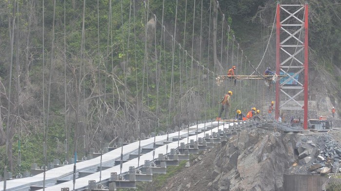 Progres Jembatan Darurat Gladak Perak di Lumajang Usai Diterjang Erupsi Sejumlah pekerja menyelesaikan pembangunan jembatan gantung Gladak Perak di Lumajang, Jawa Timur, Sabtu (9/4/2022). Kementerian Pekerjaan Umum dan Perumahan Rakyat membangun jembatan gantung darurat tersebut untuk dilewati sementara oleh kendaraan roda dua, sebelum jembatan permanen yang rusak akibat awan panas guguran Gunung Semeru kembali dibangun. ANTARA FOTO/Seno/wsj.