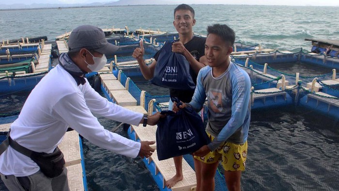 Sejumlah perwakilan jurnalis membagikan paket kebutuhan Ramadan kepada warga pesisir saat kegiatan Sahur on The Boat 2022-Ramadan Berbagi di Serang, Banten, Sabtu (9/4/2022).