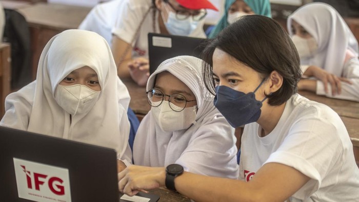 IFG BERIKAN BANTUAN FASILITAS PENDIDIKAN Seorang relawan dari Indonesia Financial Group (IFG) memberikan edukasi digital kepada siswa sekolah dasar SDN 01 Malasari pada acara pemberian bantuan renovasi dan fasilitas pendidikan di Desa Nanggung, Bogor, Jawa Barat, Sabtu (9/4/2022). Pada acara tersebut IFG memberikan bantuan berupa lima unit laptop dan 200 tas beserta alat tulisnya guna meningkatkan mutu pendidikan di wilayah 3T (terdepan, terpencil dan tertinggal). ANTARA FOTO/Muhammad Adimaja/wsj.