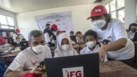 SEVP Pengembangan Bisnis IFG Rosmaylinda Nasution (kanan) bersama Sekretaris Perusahaan Indonesia Financial Group (IFG) Beko Setiawan (kiri) memberikan edukasi digital kepada siswa sekolah dasar SDN 01 Malasari pada acara pemberian bantuan renovasi dan fasilitas pendidikan di desa Nanggung, Bogor, Jawa Barat, Sabtu (9/4/2022). Pada acara tersebut IFG memberikan bantuan berupa lima unit laptop dan 200 tas beserta alat tulisnya, guna mendukung kemajuan dan kualitas pendidikan di Indonesia untuk menciptakan SDM yang berkualitas.