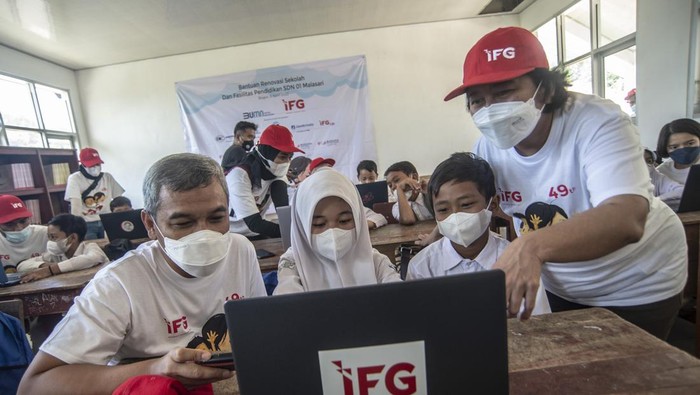 IFG BERIKAN BANTUAN FASILITAS PENDIDIKAN Seorang relawan dari Indonesia Financial Group (IFG) memberikan edukasi digital kepada siswa sekolah dasar SDN 01 Malasari pada acara pemberian bantuan renovasi dan fasilitas pendidikan di Desa Nanggung, Bogor, Jawa Barat, Sabtu (9/4/2022). Pada acara tersebut IFG memberikan bantuan berupa lima unit laptop dan 200 tas beserta alat tulisnya guna meningkatkan mutu pendidikan di wilayah 3T (terdepan, terpencil dan tertinggal). ANTARA FOTO/Muhammad Adimaja/wsj.