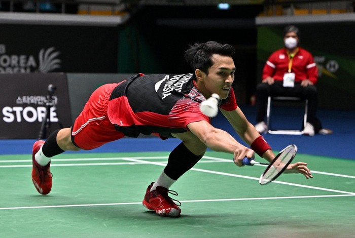 Indonesias Jonatan Christie reaches for a return against Chinas Weng Hongyang during their mens singles final match at the Korea Open Badminton Championships in Suncheon on April 10, 2022. (Photo by Jung Yeon-je / AFP)