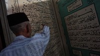 Seorang pengurus masjid menunjukkan replika Al-Quran berukuran besar di Masjid Jami Aulia, Sapuro, Pekalongan, Jawa Tengah, Sabtu (9/4/2022).