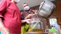 Warga menyaring minyak kelapa yang baru selesai dibuat. Minyak kelapa dinilai lebih sehat serta lebih lezat untuk memasak.