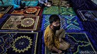 Seorang anak berkebutuhan khusus duduk di atas sajadah menunggu untuk belajar dengan tema Ramadan.
