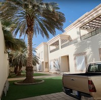 Halaman rumah terlihat luas dan juga asri. Ditumbuhi dengan pohon-pohon kurma yang cukup besar, rumah tersebut jadi tampak rindang dan sejuk. Dominasi warna coklat pada desain bangunan rumah juga membuatnya semakin sedap dipandang. Foto: YouTube/Fenny Listiana