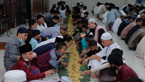 Sejumlah warga Muslimat menyiapkan makanan di atas lembaran daun pisang untuk makan bersama atau megibung saat waktu berbuka puasa di Masjid Baitul Makmur, Denpasar, Bali, Jumat (8/4/2022). Kegiatan megibung yang digelar saat waktu berbuka puasa tersebut untuk menyemarakkan bulan Ramadhan 1443 Hijriah dan sekaligus ajang menjalin silaturahmi. ANTARA FOTO/Nyoman Hendra Wibowo/wsj.
