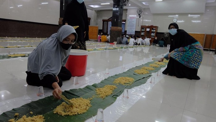 Tradisi Megibung, Silaturahmi Sambil Buka Puasa Bersama di Bali Sejumlah warga Muslimat menyiapkan makanan di atas lembaran daun pisang untuk makan bersama atau megibung saat waktu berbuka puasa di Masjid Baitul Makmur, Denpasar, Bali, Jumat (8/4/2022). Kegiatan megibung yang digelar saat waktu berbuka puasa tersebut untuk menyemarakkan bulan Ramadhan 1443 Hijriah dan sekaligus ajang menjalin silaturahmi. ANTARA FOTO/Nyoman Hendra Wibowo/wsj.