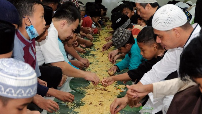 Tradisi Megibung, Silaturahmi Sambil Buka Puasa Bersama di Bali Sejumlah warga Muslimat menyiapkan makanan di atas lembaran daun pisang untuk makan bersama atau megibung saat waktu berbuka puasa di Masjid Baitul Makmur, Denpasar, Bali, Jumat (8/4/2022). Kegiatan megibung yang digelar saat waktu berbuka puasa tersebut untuk menyemarakkan bulan Ramadhan 1443 Hijriah dan sekaligus ajang menjalin silaturahmi. ANTARA FOTO/Nyoman Hendra Wibowo/wsj.