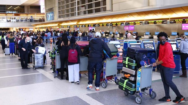 Selanjutnya, ada Bandara Internasional Los Angeles. Orang-orang terlihat mengantre untuk check in di terminal internasional pada 21 Desember 2021. Bandara ini memiliki 48 juta penumpang di tahun tersebut. (Mario Tama/Getty Images/CNN)