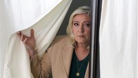 Dari 12 kandidat, Macron diprediksi lolos ke putaran kedua dan bersaing ketat dengan politikus sayap kanan, Marine Le Pen. Tampak Le Pen ke luar dari bilik TPS.