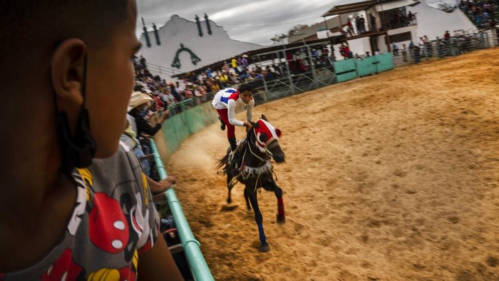 Cuba Rodeo A cowboy wearing a mask as a precaution amid the spread of COVID-19 looks at other comrades during the competition at the Boyeros Cattlemen's fair rodeo during the International Agricultural Fair Fiagrop 2022 in Havana, Cuba, Friday, April 8, 2022. The rodeo in Cuba is a tradition over two centuries old. (AP Photo/Ramon Espinosa)