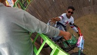 Pushpender mengulurkan tangannya saat mengendarai motornya yang bergerak cepat untuk menerima uang kertas yang ditawarkan oleh seorang penonton.