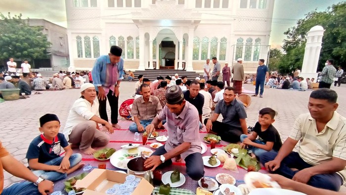 Warga mempersiapkan hidang yang berisi makanan untuk berbuka puasa pada tradisi kenduri Ramadhan di Banda Aceh, Aceh, Minggu (10/4/2022). Kenduri yang dirayakan dengan cara berbuka puasa bersama di halaman masjid tersebut telah menjadi tradisi pada setiap bulan Ramadhan yang juga dilaksanakan untuk merperingati Nuzulul Quran. ANTARA FOTO / Irwansyah Putra/nym.