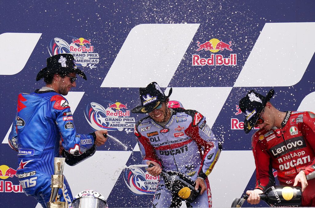 Enea Bastianini, center, of Italy, celebrates after winning the MotoGP Grand Prix of the Americas motorcycle race at the Circuit of the Americas, Sunday, April 10, 2022, in Austin, Texas. Alex Rins, left, of Spain, finished second, and Jack Miller, right, of Australia, finished third. (AP Photo/Eric Gay)