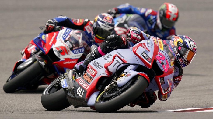 Menang MotoGP AS, Bastianini Kembali Puncaki Klasemen MotoGP Enea Bastianini, center, of Italy, celebrates after winning the MotoGP Grand Prix of the Americas motorcycle race at the Circuit of the Americas, Sunday, April 10, 2022, in Austin, Texas. Alex Rins, left, of Spain, finished second, and Jack Miller, right, of Australia, finished third. (AP Photo/Eric Gay)