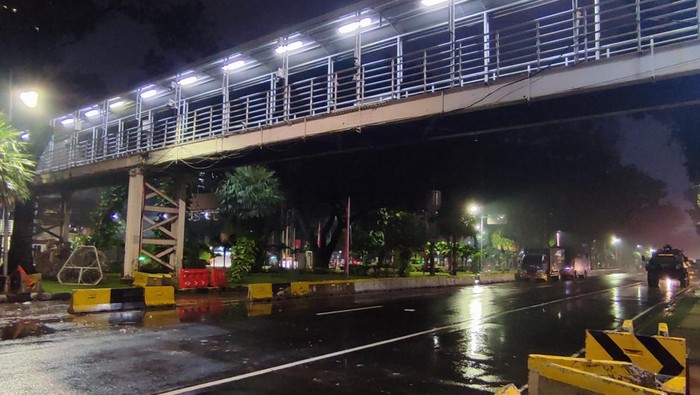 Polisi membuka barikade kawat berduri di Jl Medan Merdeka Barat, Sein (11/4/2022) malam ini setelah massa demo bubar pada pukul 17.30 WIB.