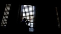 Salah seorang jemaah tengah membaca Al-Quran menunggu waktu buka puasa. Masjid Al-Azhar Kairo memiliki sejarah panjang dalam peradaban Islam di dunia. 