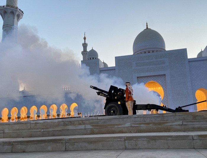 RELIGION-RAMADAN/EMIRATES A policeman is pictured as a military cannon is fired to mark sunset and the end of the fasting day, during the holy month of Ramadan at the Sheikh Zayed Grand Mosque in Abu Dhabi, United Arab Emirates, April 9, 2022. Picture taken April 9, 2022. REUTERS/Abdel Hadi Ramahi