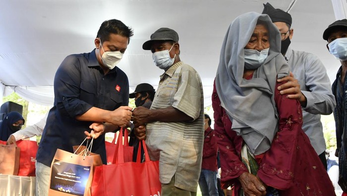 Direktur Sales Telkomsel Adiwinahyu B Sigit (kiri) menyerahkan bantuan kepada kaum duafa saat digelar Telkomsel Siaga di Bangkalan, Jawa Timur, Senin (11/4/2022). Telkomsel Siaga yang rutin digelar setiap tahun sebagai bentuk  kepedulian sosial selama bulan Ramadhan tersebut dengan memberikan santunan dan Paket Lebaran kepada anak yatim/dhuafa dari sejumlah yayasan panti asuhan di Pulau Madura. ANTARA FOTO/Zabur Karuru/hp.