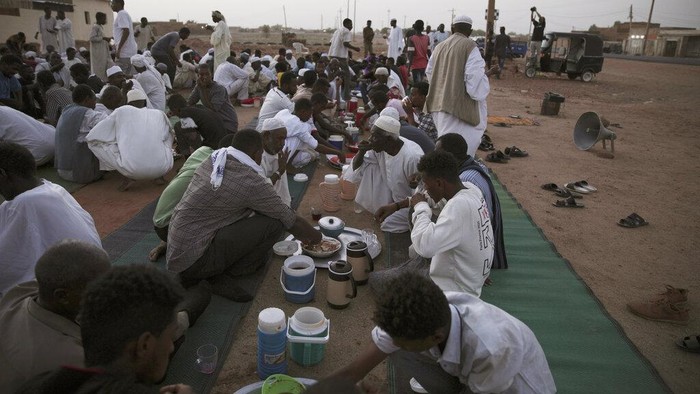 Warga Sudan Ramai-ramai Cegat Pengendara di Jalan, Ada Apa? A plate is filled with chickpeas and dates ready to be provided to observing Muslims to break their Ramadan fast along the side of the road of the Jazeera State highway in the village of al-Nuba, about 50 kilometers south of Sudan's capital, Khartoum, Friday, April 8, 2022. (AP Photo/Marwan Ali)