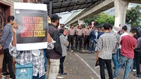 Massa tampak membawa sejumlah poster dalam aksi yang digelar Minggu (10/4) lalu.