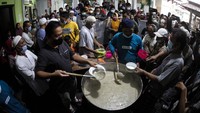 Petugas membagikan takjil Bubur Samin Banjar kepada warga di halaman Masjid Darussalam, Solo, Jawa Tengah, Minggu (3/4/2022). (Maulana Surya/Antara Foto)