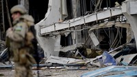 Seorang prajurit berjaga di area sekitar Bandara Internasional Mykolaiv yang hancur imbas perang Rusia-Ukraina.