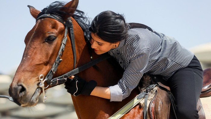 IRAQ-SPORTS/WOMEN-RIDING An Iraqi woman rides a horse during a training session in the sport traditionally practiced by men, at the Equestrian Club in Basra, Iraq, March 29, 2022. Picture taken March 29, 2022. REUTERS/Essam al-Sudani