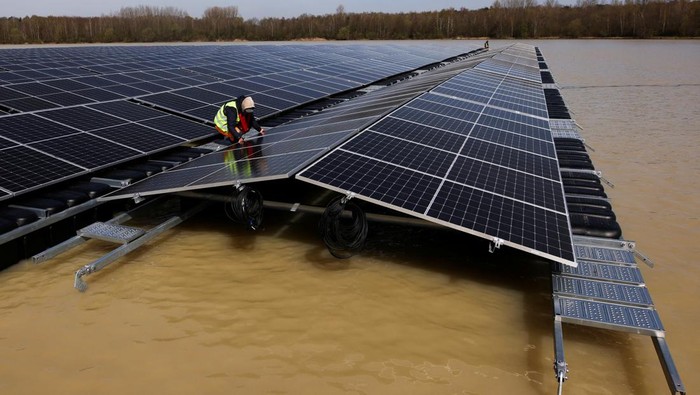 A boat pulls solar panels towards a floating photovoltaic power plant on lake Silbersee (Lake Silver) in Haltern am See, Germany, April 11, 2022. Picture taken with a drone. REUTERS/Erol Dogrudogan     TPX IMAGES OF THE DAY
