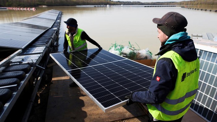 A boat pulls solar panels towards a floating photovoltaic power plant on lake Silbersee (Lake Silver) in Haltern am See, Germany, April 11, 2022. Picture taken with a drone. REUTERS/Erol Dogrudogan     TPX IMAGES OF THE DAY