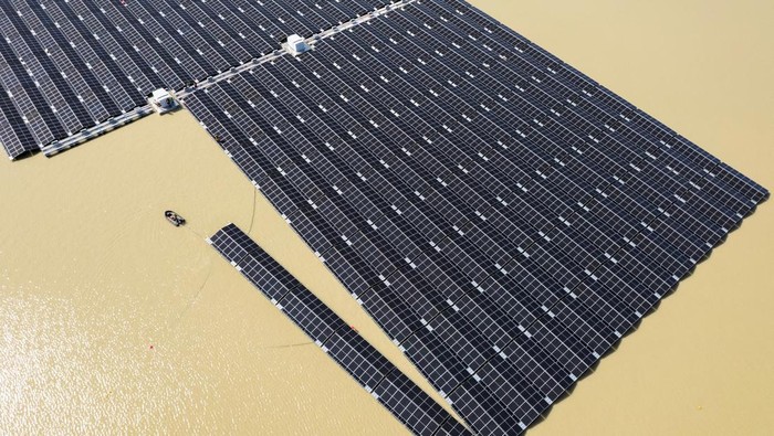 A boat pulls solar panels towards a floating photovoltaic power plant on lake Silbersee (Lake Silver) in Haltern am See, Germany, April 11, 2022. Picture taken with a drone. REUTERS/Erol Dogrudogan     TPX IMAGES OF THE DAY