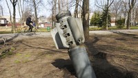 Seorang pria bersepeda di dekat serpihan rudal yang terlihat di kota Chuhuiv, wilayah Kharkiv, Ukraina, Jumat (8/4/2022). (AP Photo/Andrew Marienko).
