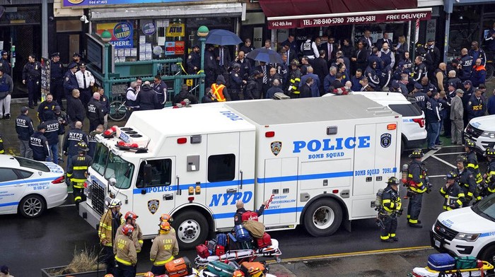 Emergency personnel gather at the entrance to a subway stop in the Brooklyn borough of New York, Tuesday, April 12, 2022. A gunman filled a rush-hour subway train with smoke and shot multiple people Tuesday, leaving wounded commuters bleeding on a platform as others ran screaming, authorities said. (AP Photo/John Minchillo)