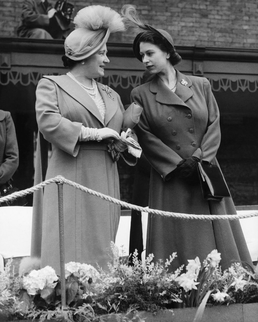 Princess Elizabeth is seen chatting with her mother Queen Elizabeth when King George VI, unseen, distributed shamrock during the Irish guards St. Patricks Day Parade at Chelsea Barracks, London on March 17, 1950. (AP Photo)