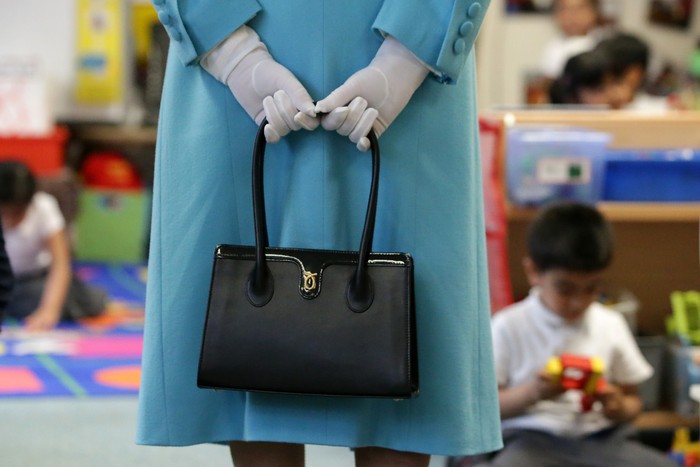 LONDON, ENGLAND - JUNE 15:  Britains Queen Elizabeth II holds her handbag as she tours the classrooms at Mayflower Primary School during a visit to Poplar in Tower Hamlets on June 15, 2017 in London, England.  The visit coincides with commemorations for the centenary of the bombing of Upper North Street School during the First World War.  (Photo by Daniel Leal-Olivas/WPA Pool/Getty Images)
