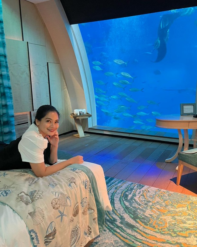 Selama di Singapura Titi Kamal menginap di sebuah hotel mewah yang memiliki pemandangan akuarium bawah laut. Raut wajah bahagia pun tampak jelas di wajah Titi Kamal. Foto: Instagram/@titi_kamall
