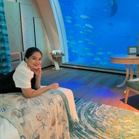 Selama di Singapura Titi Kamal menginap di sebuah hotel mewah yang memiliki pemandangan akuarium bawah laut. Raut wajah bahagia pun tampak jelas di wajah Titi Kamal. Foto: Instagram/@titi_kamall