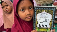 Seorang anak memperlihatkan buku Iqra di depan kamera saat CT Arsa Foundation menggelar aksi sosial gebrag dan literasi agama.