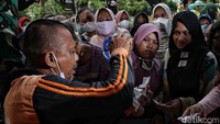 Petugas sabar melayani pengantre sembako murah.