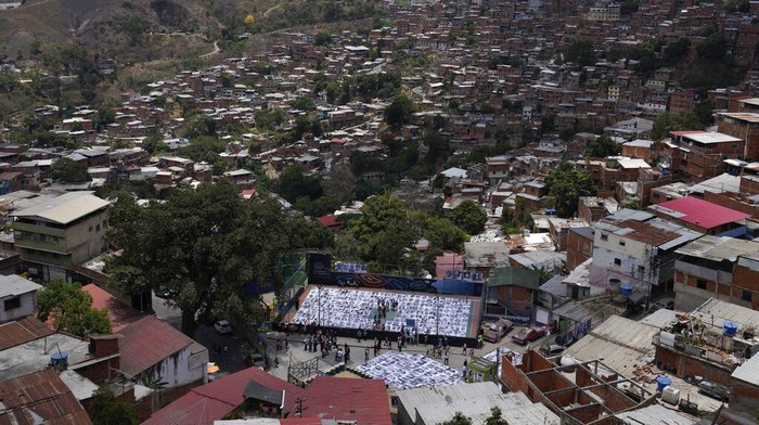 Cara Warga Daerah Kumuh di Venezuela Ubah Stigma Buruk People visit the photographic installation Inside Out, in the San Blas community of Petare, in Caracas, Venezuela, Tuesday, April 12, 2022. The initiative created by the French street artist Jean RenΓ©, better known as JR, in an effort to overcome the stigma of violence that accompanies the neighborhood. (AP Photo/Ariana Cubillos)
