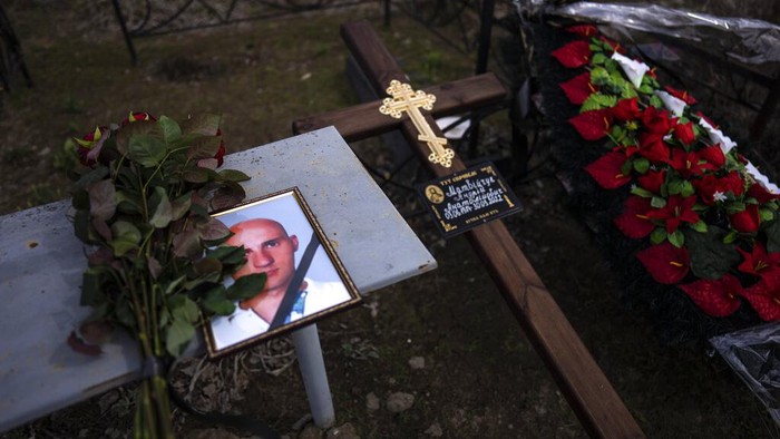 Duka Keluarga Korban Pembantaian di Bucha Ukraina A portrait of Andriy Matviychuk, 37, who served as territorial defense soldier and was captured and killed by Russian army in Bucha, during his funeral, Ukraine, Tuesday, April 12, 2022. (AP Photo/Rodrigo Abd)