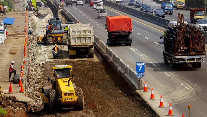 Foto udara pekerja mengoperasikan alat berat saat menyelesaikan proyek pelebaran jalan tol Jakarta-Cikampek di Karawang, Jawa Barat, Rabu (13/4/2022). Kementerian Pekerjaan Umum dan Perumahan Rakyat (PUPR) menargetkan pengerjaan pelebaran Jalan Tol Jakarta–Cikampek jalur B KM 67–KM 50 akan selesai pada H-10 Lebaran 2022 sebagai antisipasi untuk ruas fungsional terbatas khususnya kendaraan kecil pada arus balik Lebaran 2022. ANTARA FOTO/M Ibnu Chazar/wsj.