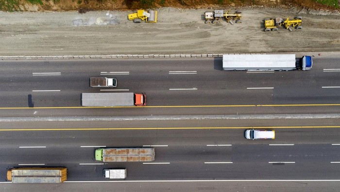 Foto udara pekerja mengoperasikan alat berat saat menyelesaikan proyek pelebaran jalan tol Jakarta-Cikampek di Karawang, Jawa Barat, Rabu (13/4/2022). Kementerian Pekerjaan Umum dan Perumahan Rakyat (PUPR) menargetkan pengerjaan pelebaran Jalan Tol Jakarta–Cikampek jalur B KM 67–KM 50 akan selesai pada H-10 Lebaran 2022 sebagai antisipasi untuk ruas fungsional terbatas khususnya kendaraan kecil pada arus balik Lebaran 2022. ANTARA FOTO/M Ibnu Chazar/wsj.