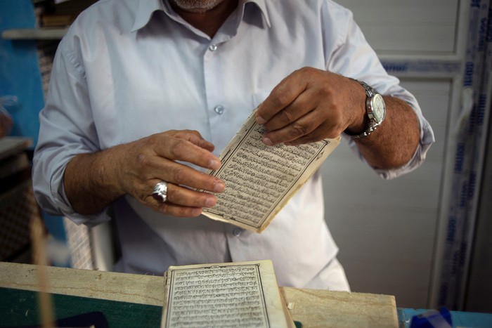 Libyan volunteers repair copies of the Koran during the holy of month of Ramadan in Tripoli, Libya  April 10, 2022. Picture taken April 10, 2022.  REUTERS/Nada Harib